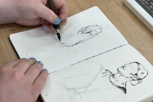 Bilde som viser student som tegner i skissebok.